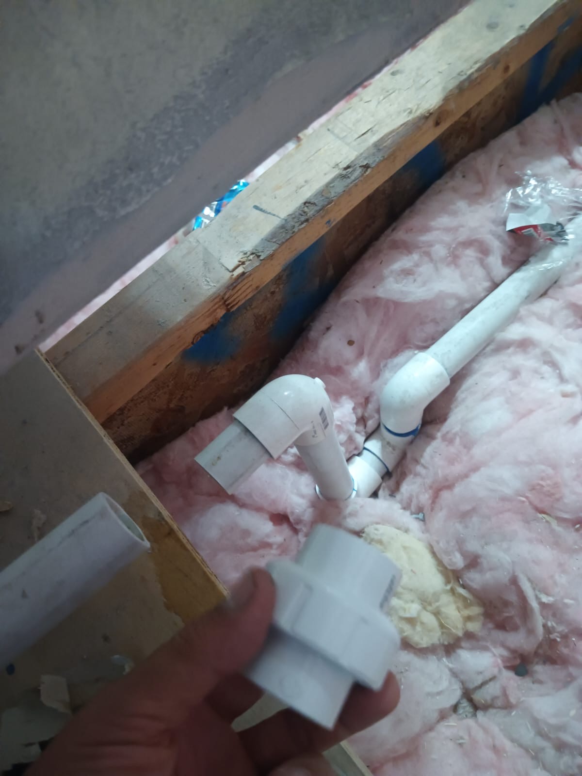 PVC condensate drain lines being installed in attic insulation