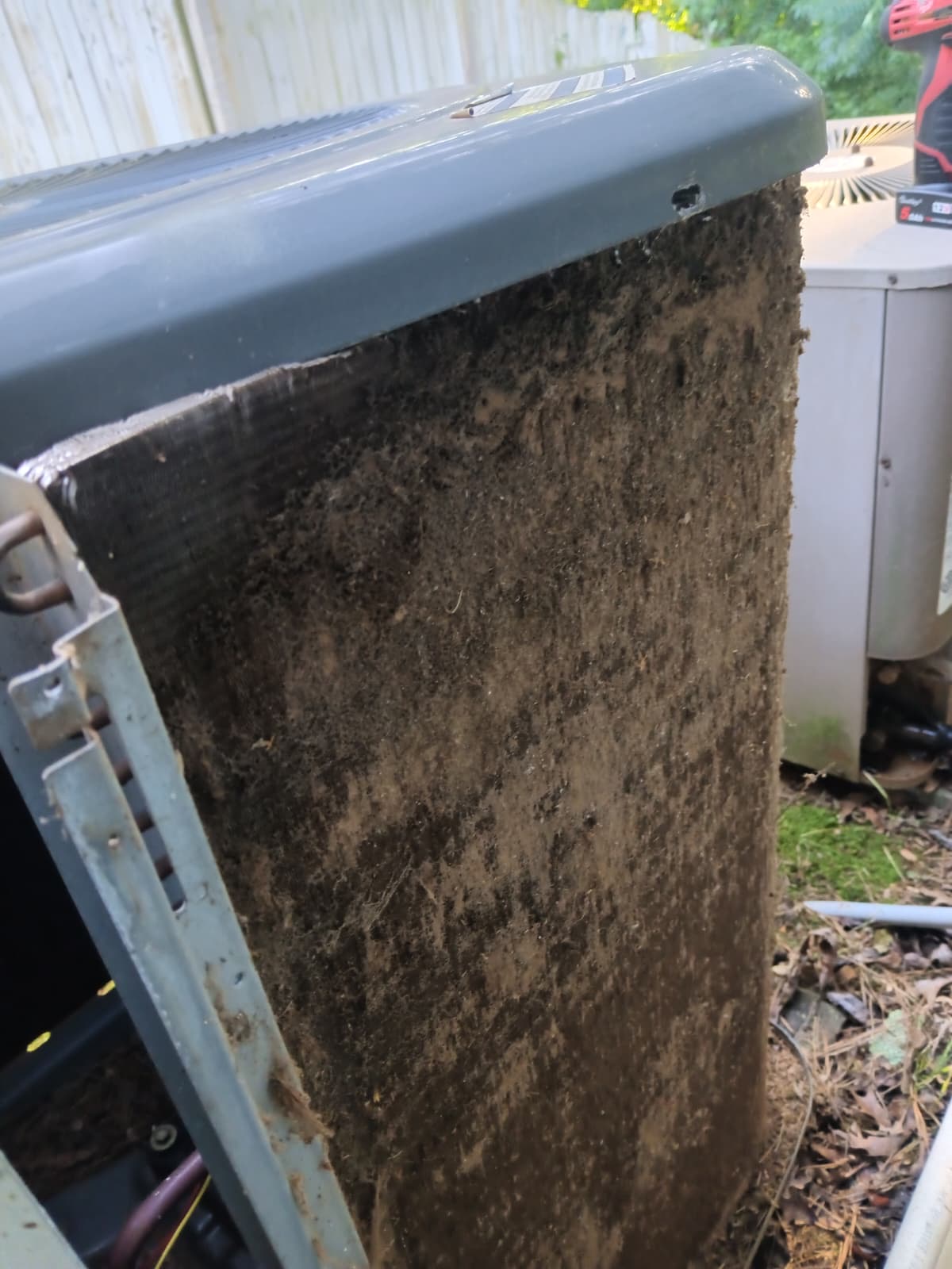Condenser coil packed with mud and debris before cleaning
